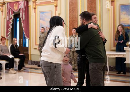 Kiew, Ukraine. März 2024. Der ukrainische Präsident Wolodymyr Zelenskyj, rechts, wird von Familienmitgliedern eines gefallenen Soldaten umarmt, nachdem sie ihnen bei einer Zeremonie in der Preisverleihungshalle des Mariinski-Palastes am 7. März 2024 in Kiew, Ukraine, die Wohnungsurkunden überreicht haben. Kredit: Ukrainischer Ratsvorsitz/Pressestelle Des Ukrainischen Präsidenten/Alamy Live News Stockfoto