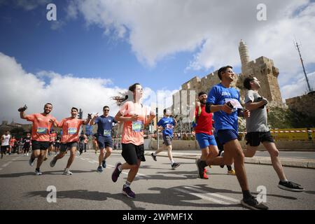 Jerusalem, Israel. März 2024. Die Läufer nehmen am Internationalen Jerusalem-Marathon Teil. Die Menschen nehmen am 13. Jährlichen Internationalen Jerusalem-Marathon in Jerusalem Teil. Viele Teilnehmer trugen in diesem Jahr Hemden und rannten mit Schildern, die auf die Geiseln aufmerksam machten, die am 7. Oktober von der Hamas entführt wurden und immer noch in Gaza festgehalten werden. Sie wurde zu Ehren der israelischen Verteidigungskräfte „IDF“ und der Sicherheitskräfte während des anhaltenden Krieges mit der Hamas in Gaza abgehalten. Quelle: SOPA Images Limited/Alamy Live News Stockfoto