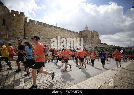 Jerusalem, Israel. März 2024. Die Läufer nehmen am Internationalen Jerusalem-Marathon Teil. Die Menschen nehmen am 13. Jährlichen Internationalen Jerusalem-Marathon in Jerusalem Teil. Viele Teilnehmer trugen in diesem Jahr Hemden und rannten mit Schildern, die auf die Geiseln aufmerksam machten, die am 7. Oktober von der Hamas entführt wurden und immer noch in Gaza festgehalten werden. Sie wurde zu Ehren der israelischen Verteidigungskräfte „IDF“ und der Sicherheitskräfte während des anhaltenden Krieges mit der Hamas in Gaza abgehalten. Quelle: SOPA Images Limited/Alamy Live News Stockfoto