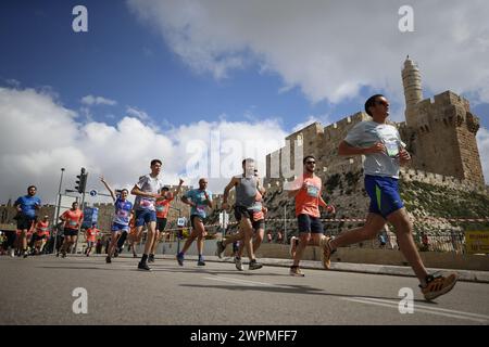 Jerusalem, Israel. März 2024. Die Läufer nehmen am Internationalen Jerusalem-Marathon Teil. Die Menschen nehmen am 13. Jährlichen Internationalen Jerusalem-Marathon in Jerusalem Teil. Viele Teilnehmer trugen in diesem Jahr Hemden und rannten mit Schildern, die auf die Geiseln aufmerksam machten, die am 7. Oktober von der Hamas entführt wurden und immer noch in Gaza festgehalten werden. Sie wurde zu Ehren der israelischen Verteidigungskräfte „IDF“ und der Sicherheitskräfte während des anhaltenden Krieges mit der Hamas in Gaza abgehalten. (Foto: Saeed Qaq/SOPA Images/SIPA USA) Credit: SIPA USA/Alamy Live News Stockfoto