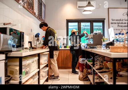 Bandung, Indonesien. März 2024. Sri Ayu (R) arbeitet am 8. März 2024 in einem Coffee Shop in Bandung, West Java, Indonesien. Sri Ayu ist eine sehbehinderte Frau und arbeitet als Barista in Bandung, Indonesien. Am 8. März, dem Internationalen Frauentag, machte sie wie gewohnt Kaffee für Gäste im Café. Sri Ayu möchte ihre beruflichen Fähigkeiten weiter verbessern und ein ausgezeichneter Barista werden. Quelle: Septianjar Muharam/Xinhua/Alamy Live News Stockfoto
