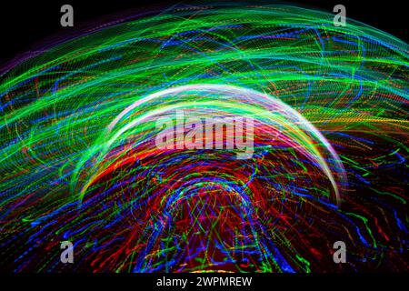 Karneval-Vergnügungspark Fahrt mit Schaukeln. Bei Nacht dreht sich eine faire Fahrt mit hellen Lila-, Rot-, Grün- und Gelblichtern. Stockfoto