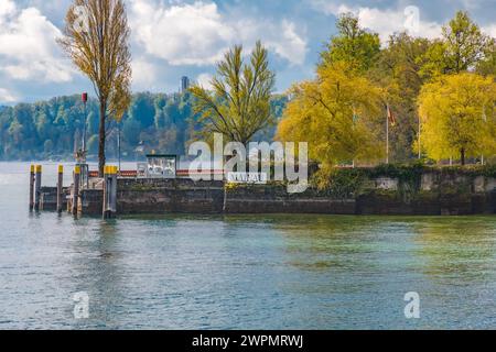 Toller Blick auf den Hafen mit einem „Mainau“-Schild an der Mauer an der Ostseite der Insel Mainau, der berühmten Insel im Bodensee,... Stockfoto