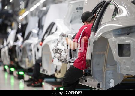 Stuttgart, Deutschland. März 2024. Ein Mitarbeiter der Porsche AG baut im Hauptwerk Zuffenhausen einen vollelektrischen Porsche Taycan. Quelle: Marijan Murat/dpa/Alamy Live News Stockfoto