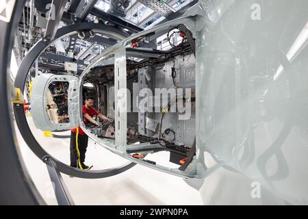 Stuttgart, Deutschland. März 2024. Ein Mitarbeiter der Porsche AG baut im Hauptwerk Zuffenhausen einen vollelektrischen Porsche Taycan. Quelle: Marijan Murat/dpa/Alamy Live News Stockfoto