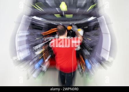 Stuttgart, Deutschland. März 2024. Ein Mitarbeiter der Porsche AG baut im Hauptwerk Zuffenhausen einen vollelektrischen Porsche Taycan. Quelle: Marijan Murat/dpa/Alamy Live News Stockfoto