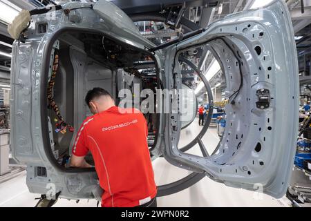 Stuttgart, Deutschland. März 2024. Ein Mitarbeiter der Porsche AG baut im Hauptwerk Zuffenhausen einen vollelektrischen Porsche Taycan. Quelle: Marijan Murat/dpa/Alamy Live News Stockfoto