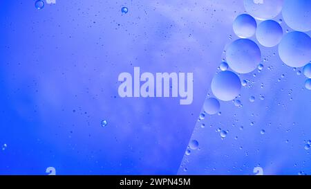 Abstrakter blauer bunter Hintergrund mit Öl auf Wasseroberfläche. Öltropfen im Wasser abstraktes psychedelisches, abstraktes Bild. Stockfoto