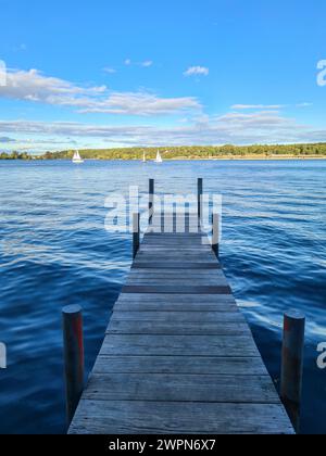 Blick auf den blauen Himmel am sonnigen Horizont von der schattigen Fußgängerbrücke im Vordergrund des Bildes, Wannsee, Berlin, Deutschland Stockfoto