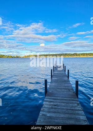 Blick auf den blauen Himmel am sonnigen Horizont von der schattigen Fußgängerbrücke im Vordergrund des Bildes, Wannsee, Berlin, Deutschland Stockfoto