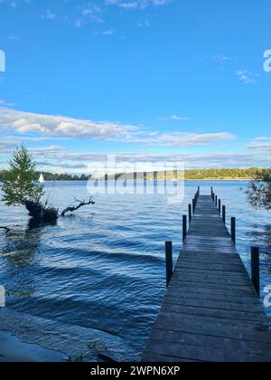 Blick auf den blauen Himmel am sonnigen Horizont von der schattigen Fußgängerbrücke im Vordergrund des Bildes, Wannsee, Berlin, Deutschland Stockfoto