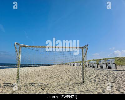 Blick durch ein Fußballnetz zum blauen Himmel über dem weißen Strand von Markgrafenheide, Ostsee, Deutschland Stockfoto