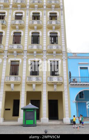 048 Gelb-grünes und weiß gefärbtes Gomez Vila Gebäude aus dem Jahr 1909, 2001 umgebaut, Plaza Vieja - Old Square - Ostseite entlang Mercaderes St. Havanna-Kuba. Stockfoto