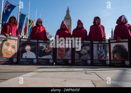 London, Großbritannien. März 2024. Demonstranten halten Plakate auf dem Parliament Square in London. Iranische Frauen versammelten sich auf dem Parlamentsplatz bei der Statue von Millicent Fawcett, um den Internationalen Frauentag und ihren Kampf gegen das iranische Regime zu feiern. Quelle: SOPA Images Limited/Alamy Live News Stockfoto