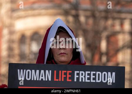 London, Großbritannien. März 2024. Ein Demonstrant hält ein Plakat auf dem Parlamentsplatz. Iranische Frauen versammelten sich auf dem Parlamentsplatz bei der Statue von Millicent Fawcett, um den Internationalen Frauentag und ihren Kampf gegen das iranische Regime zu feiern. Quelle: SOPA Images Limited/Alamy Live News Stockfoto