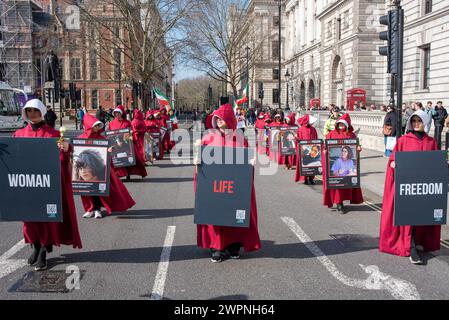 London, Großbritannien. März 2024. Die Demonstranten halten während des Marsches zur iranischen Botschaft Plakate und weiße Rosen. Iranische Frauen versammelten sich auf dem Parlamentsplatz bei der Statue von Millicent Fawcett, um den Internationalen Frauentag und ihren Kampf gegen das iranische Regime zu feiern. Quelle: SOPA Images Limited/Alamy Live News Stockfoto