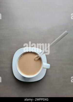 Latte in einer weißen Tasse mit Glasstroh Stockfoto