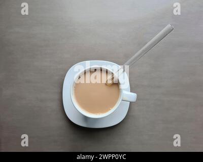 Latte in einer weißen Tasse mit Glasstroh Stockfoto