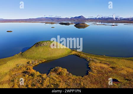 Pseudocrater in Myvatn bei Skrutustadir. Blick auf Hlidarfjall und die Dampfsäulen der geothermischen Kraftwerke am Krafla Vulkan und Namaskard. Stockfoto