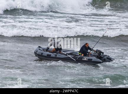 Zwei Männer trotzen dem Meer, um in einem Schlauchboot anzugeln. Pazifik, vor der Küste Chiles. Stockfoto