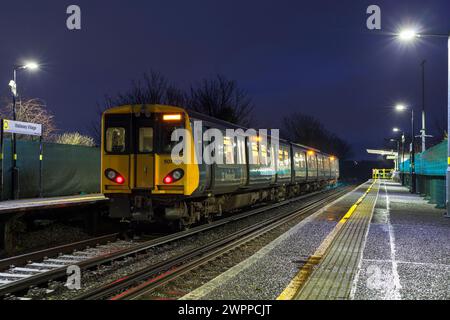 Merseyrail Electrics Retro blau und grau lackiert Klasse 507 dritter elektrischer Zug 507001 am Bahnhof Wallasey Village bei Nacht Stockfoto