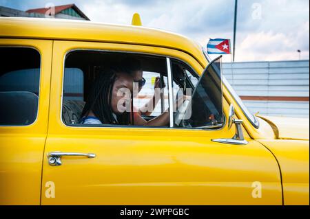 Kubanerin schläft in Havanna, Kuba, mit einem Taxi ein, während der Fahrer lacht und lächelt. Stockfoto