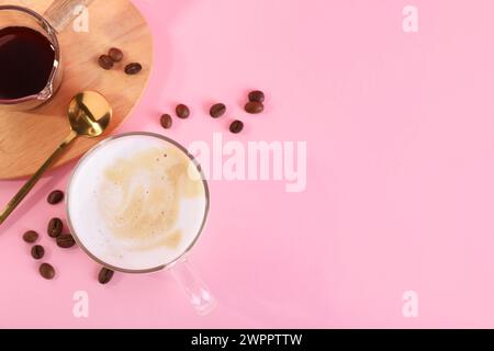 Tasse frischen Kaffee und Bohnen auf rosafarbenem Tisch, flach gelegen. Leerzeichen für Text Stockfoto