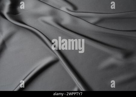 Textur aus schwarzem, zerknittertem Seidenstoff als Hintergrund, Nahaufnahme Stockfoto