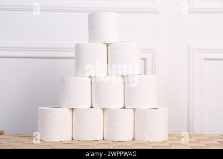 Pyramide von Toilettenpapierrollen auf dem Korbtisch Stockfoto