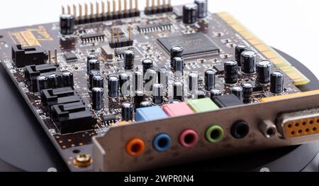 Detaillierte Nahaufnahme einer alten Desktop-PC-Soundkarte mit freiliegenden elektronischen Komponenten, Kondensatoren Widerständen und farbcodierten Audio-Eingang-jac Stockfoto