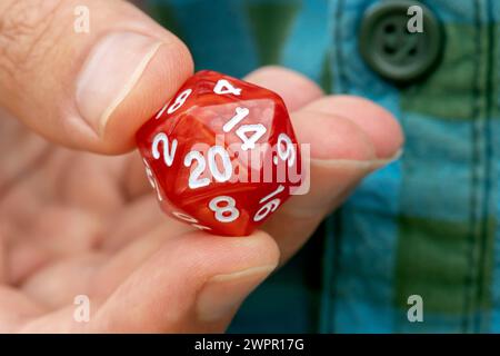 Hand mit 20-seitigen d20-Würfeln für RPG-Spiele, Finger-Nahaufnahme, eine Person, Rollenspiele, larp Live-Action-Rollenspiele und Brettspiele, ge Stockfoto