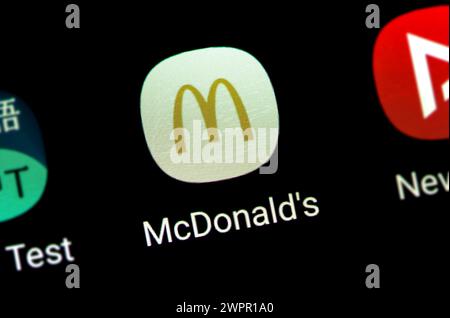 Eine vergrößerte Ansicht eines Smartphone-Bildschirms mit dem McDonalds-Anwendungssymbol umgeben von anderen App-Symbolen, schneller Fuß-Lieferung, MCD-Markenanwendung auf einem s Stockfoto