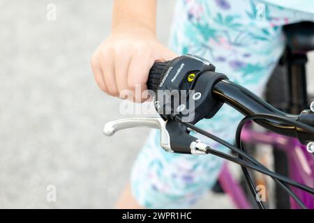 Ein Kind, das den Lenker eines Fahrrads greift, den Schalt- und Bremshebel zeigt, Detailaufnahme der Hand, eine Person, Radfahren und Radfahren, Fahrrad Stockfoto