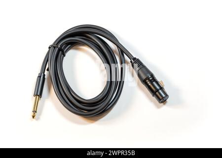 Schwarzes Spiralkabel mit 1 4-Zoll-Buchse an einem Ende und einem XLR-Stecker am anderen Ende, isoliert auf weißem Hintergrund, niemand. Beruf Stockfoto