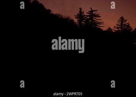 Silhouette eines Mondaufgangs auf dem Mount Lowe in den San Gabriel Mountains am Mount Wilson, Kalifornien, USA. Stockfoto