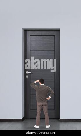 Mann, der vor der Tür steht, Rückansicht Stockfoto