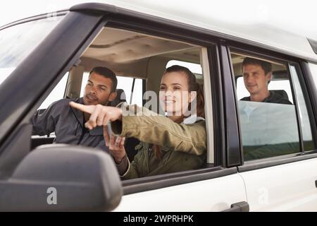 Freunde, Auto und Zeiger auf Roadtrip mit Reisen für Abenteuer, Urlaub und Sightseeing mit Glück auf dem Land. Frauen, Männer und Einfahren Stockfoto