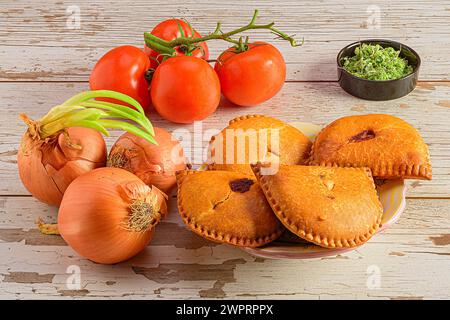 Die hausgemachten Empanadas mit Gemüse und Rosmarin auf einem Holztisch. Stockfoto