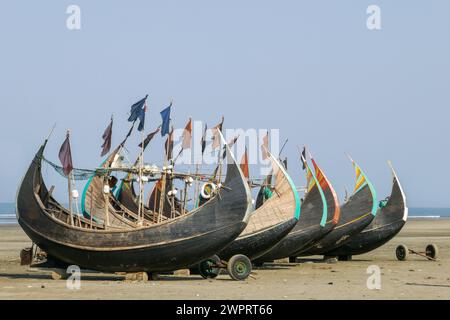 Farbenfrohe traditionelle Holzfischboote, bekannt als Mondboote, ruhen trocken am Inani Beach, Cox's Bazar, Bangladesch Stockfoto