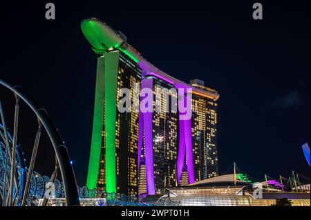Singapur, 24. Januar 2024: Marina Bay Sands in Singapur seine lebendige Beleuchtung spiegelt sich in den umliegenden Gewässern. ArtScience Museum und Helix Bridge Stockfoto