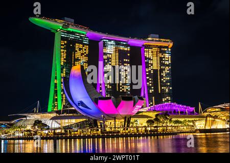 Singapur, 24. Januar 2024: Marina Bay Sands in Singapur seine lebendige Beleuchtung spiegelt sich in den umliegenden Gewässern. ArtScience Museum und Helix Bridge Stockfoto