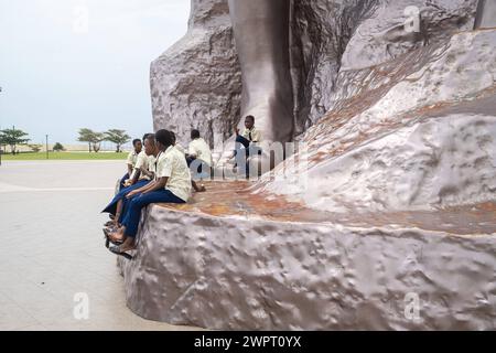 Monument Amazone Benin, Cotonou März 2024: Seit mitte 2022 steht das neue 30 Meter hohe Wahrzeichen der westafrikanischen Staat Benin. Die Amazone soll an die historische, rein weibliche Militäreinheit der Agojie auch Dahomey-Amazonen erinnern. Schuljugendlichen sitzen am Fusse der Statur. *** Monument Amazonas Benin, Cotonou März 2024 das neue 30 Meter hohe Wahrzeichen des westafrikanischen Staates Benin steht seit Mitte 2022 der Amazonas soll an die historische, weibliche Militäreinheit der Agojie erinnern, auch bekannt als die Dahomey Amazonen-Schulkinder, die am Fuße des Th sitzen Stockfoto