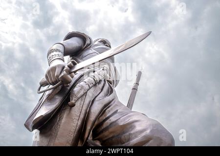 Monument Amazone Benin, Cotonou März 2024: Seit mitte 2022 steht das neue 30 Meter hohe Wahrzeichen der westafrikanischen Staat Benin. Die Amazone soll an die historische, rein weibliche Militäreinheit der Agojie auch Dahomey-Amazonen erinnern. *** Monument Amazone Benin, Cotonou März 2024 das neue 30 Meter hohe Wahrzeichen des westafrikanischen Bundesstaates Benin steht seit Mitte 2022 der Amazonas soll an die historische, weibliche Militäreinheit der Agojie, auch bekannt als Dahomey Amazonen, erinnern Stockfoto