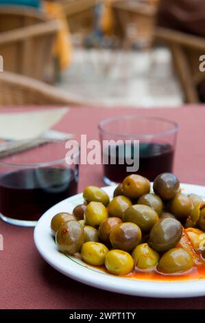 Grüne Oliven und zwei Gläser Rotwein. Ansicht schließen. Stockfoto