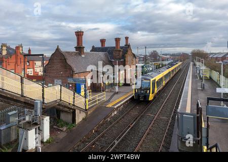 Merseyrail Stadler Baureihe 777 Elektrozug 777006 am Bahnhof Ellesmere Port in Cheshire, Großbritannien mit den Bahnhofsgebäuden Stockfoto