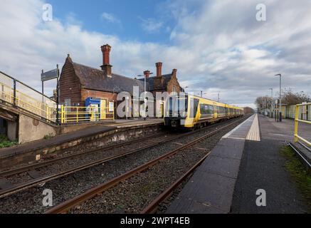 Merseyrail Stadler Baureihe 777 Elektrozug 777006 am Bahnhof Ellesmere Port in Cheshire, Großbritannien mit den Bahnhofsgebäuden Stockfoto