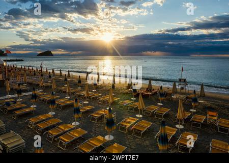 Leerer Strand und Strandliegen, Sonnenaufgang, Spotorno, Riviera di Ponente, Ligurien, Italien Stockfoto