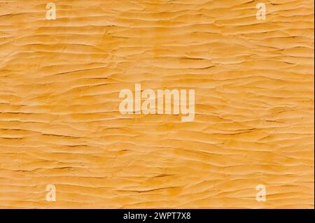 Wellige Lehmputzwand, Stein, Beige, Lehmputz, Baumaterial, Alternative, Wand, Wand, Textur, Hintergrund, gelb, Ocker, sonnig Stockfoto