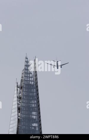 Airbus-Flugzeug im Flug über dem Shard City Wolkenkratzer Gebäude, London, England, Großbritannien Stockfoto