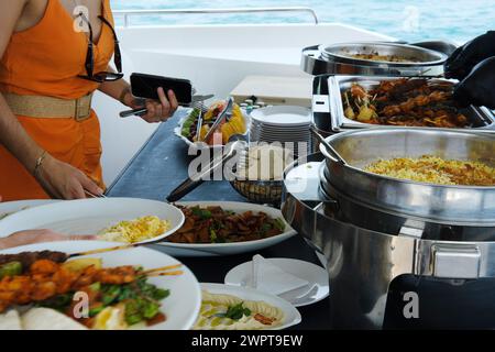 Yachtgäste in Dubai werden an einem sonnigen Tag ein Gourmet-Buffet mit verschiedenen Gerichten serviert Stockfoto